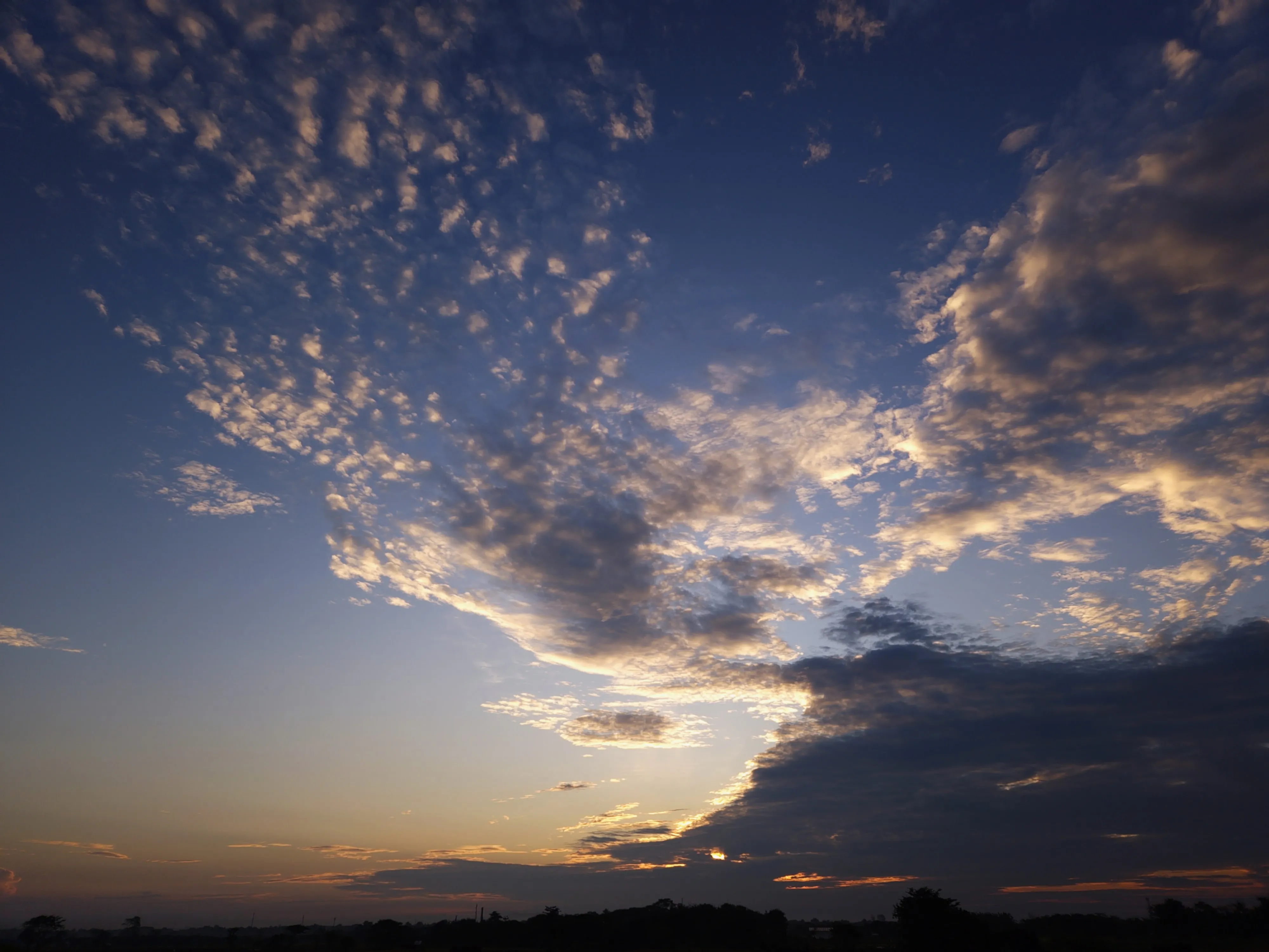 Golden sunrise illuminating dramatic clouds above the horizon